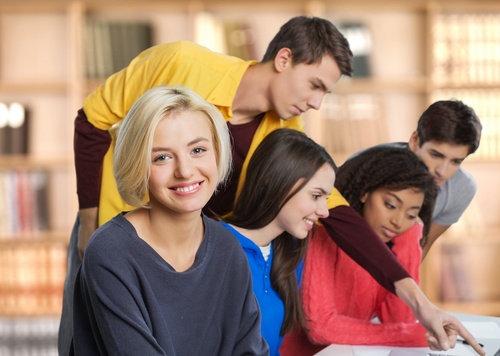 Male and female students in school classroom Stock Photo