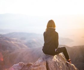 Man sitting on the top of the rock Stock Photo