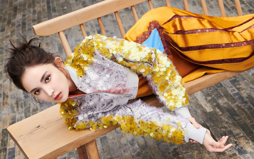 Pretty girl in fashionable clothes lying on wooden chair Stock Photo