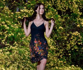 Slim fit beautiful girl and yellow flowering shrubs background Stock Photo