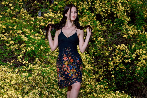 Slim fit beautiful girl and yellow flowering shrubs background Stock Photo