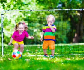 Two little kids playing football Stock Photo