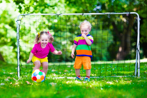 Two little kids playing football Stock Photo