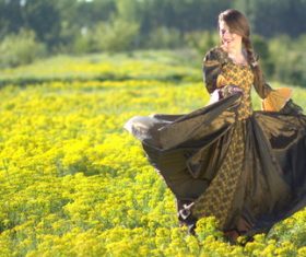 Woman dancing in yellow flower field Stock Photo
