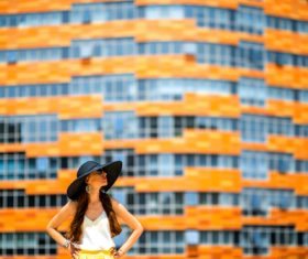 Woman in front of orange building Stock Photo