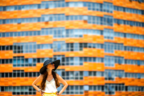 Woman in front of orange building Stock Photo