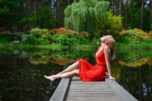 Woman sitting on the wooden bridge enjoying the natural air Stock Photo