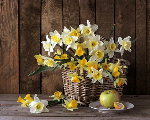 Apple with yellow and white flowers in basket Stock Photo