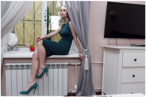 Beautiful woman sitting on the windowsill posing Stock Photo