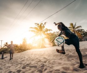 Children playing football on the beach Stock Photo