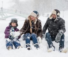 Family of three playing in the snow Stock Photo