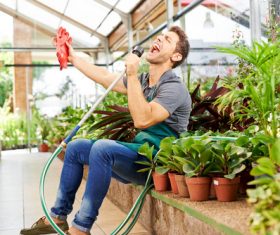 Funny young man in the flower shed Stock Photo