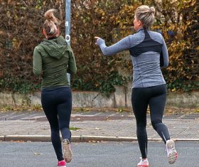 Mother and daughter running outdoors Stock Photo