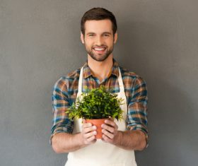Smiling man holding a pot of plants Stock Photo