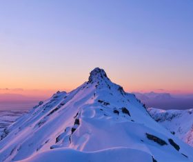 Snowy Mountain Peak with Sunrise Glow Stock Photo