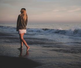 Stock Photo Girl walking on the beach back shadow
