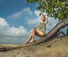 Stock Photo Pretty woman sitting on dry trunk