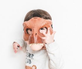 Wearing dinosaur mask for children Stock Photo