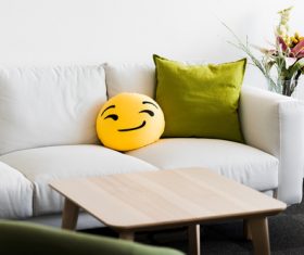 White Couch with Funny Emoji Pillow Stock Photo