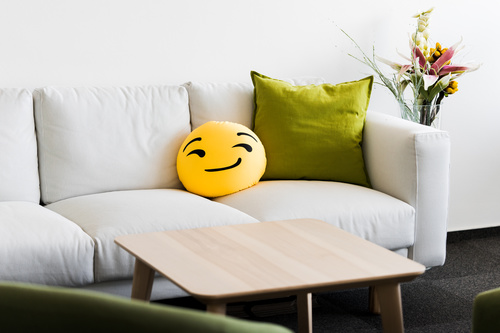 White Couch with Funny Emoji Pillow Stock Photo