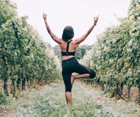 Woman practicing yoga in the vineyard Stock Photo