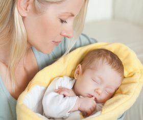 Young mother holding her sleeping baby Stock Photo 01