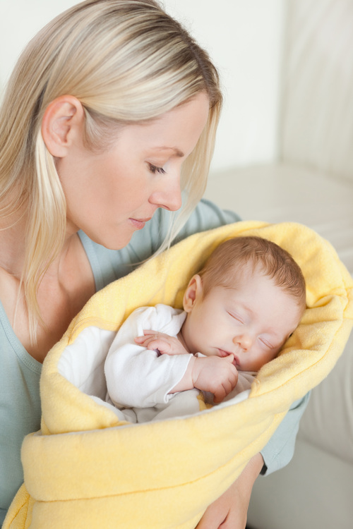 Young mother holding her sleeping baby Stock Photo 01