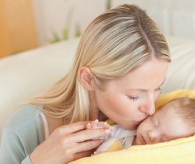 Young mother holding her sleeping baby Stock Photo 02