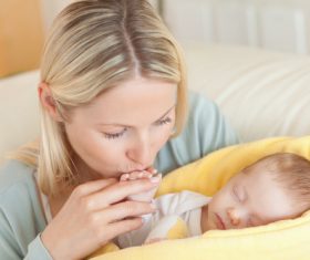 Young mother holding her sleeping baby Stock Photo 05