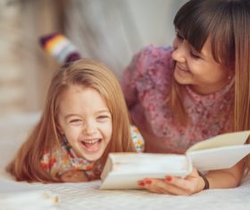 Young mother reads fairy tale book to daughter Stock Photo 02