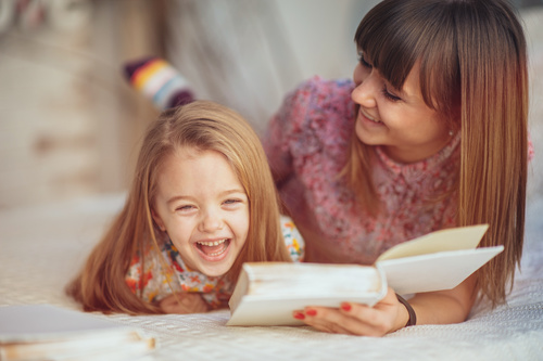 Young mother reads fairy tale book to daughter Stock Photo 02