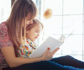 Young mother reads fairy tale book to daughter Stock Photo 03
