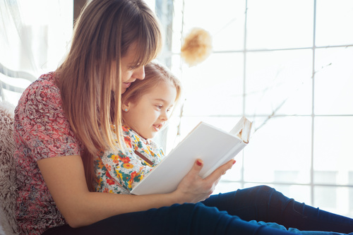 Young mother reads fairy tale book to daughter Stock Photo 03
