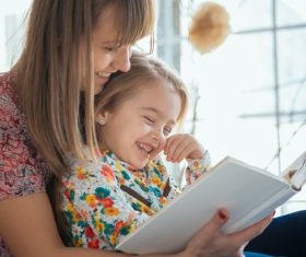Young mother reads fairy tale book to daughter Stock Photo 04