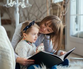 Young mother reads fairy tale book to daughter Stock Photo 05