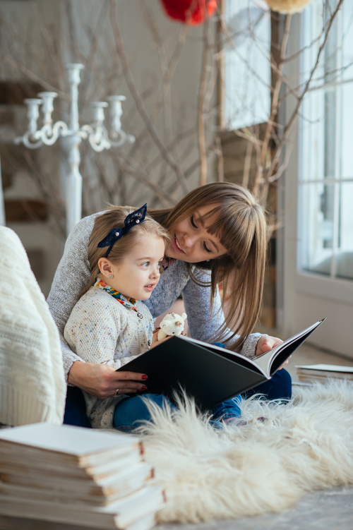 Young mother reads fairy tale book to daughter Stock Photo 05