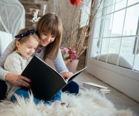 Young mother reads fairy tale book to daughter Stock Photo 06