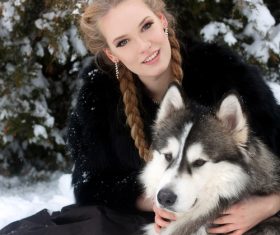 Young woman with wolf dog in snow Stock Photo 01