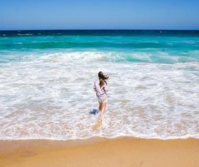 Beautiful girl back shadow standing on the beach by the sea Stock Photo