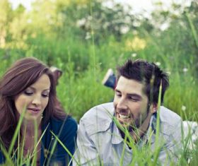 Couple lying on the grass talking Stock Photo