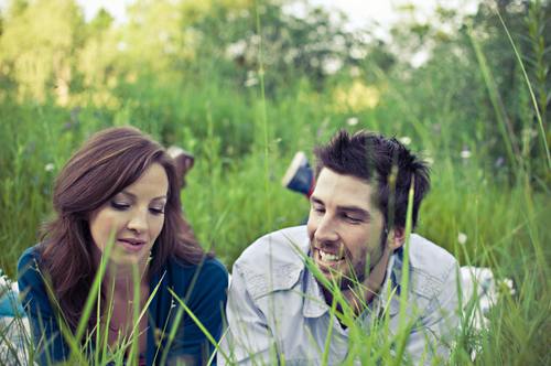 Couple lying on the grass talking Stock Photo