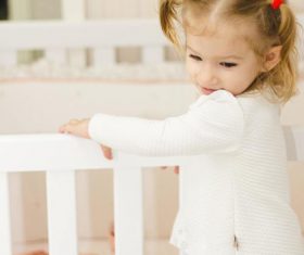 Cute blond little girl looking at newborn baby Stock Photo 02