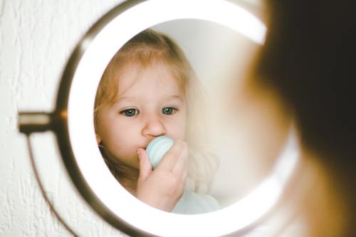 Cute blond little girl looking in the mirror Stock Photo 01