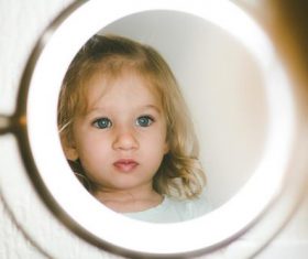 Cute blond little girl looking in the mirror Stock Photo 02