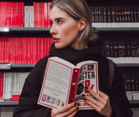 Girl reading a book in the library Stock Photo