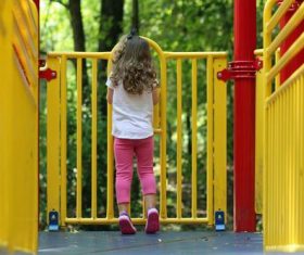 Little girl standing on the slide Stock Photo