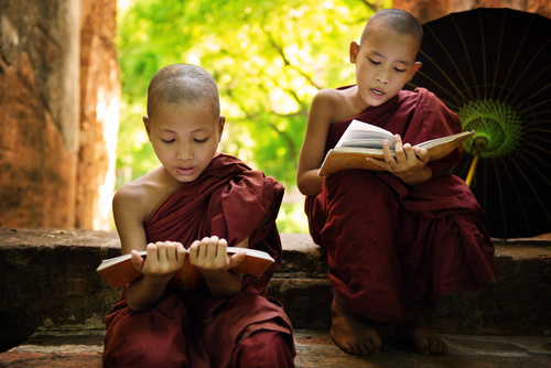 Little monk reading book Stock Photo