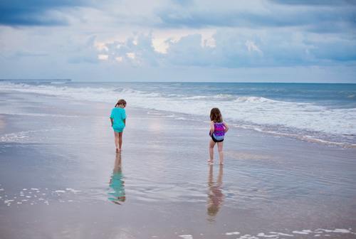Little sisters walking by the sea Stock Photo