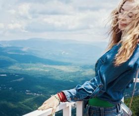 Long-haired beauty next to the guardrail on the top of the mountain Stock Photo