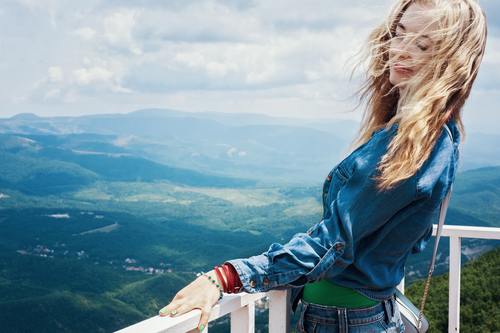 Long-haired beauty next to the guardrail on the top of the mountain Stock Photo
